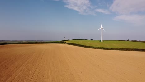 Wind-turbine-spinning-on-green-field-blue-sky