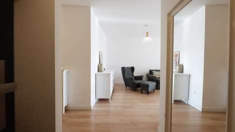 person entering through the door of a modern house leading into a bright new living room