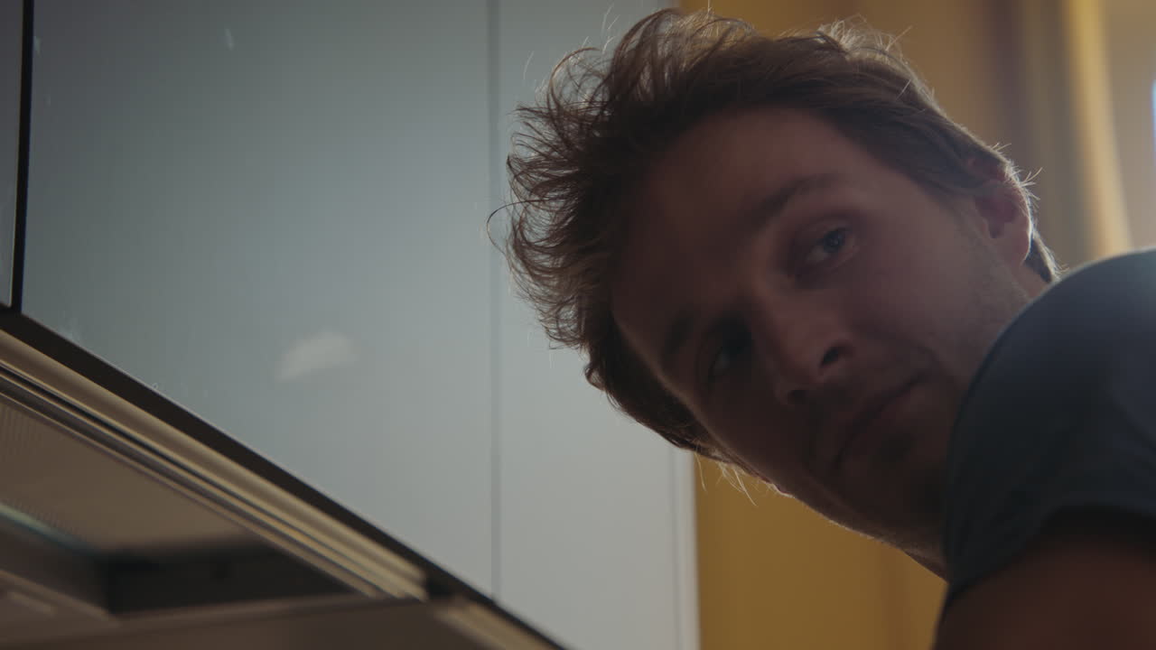 Man looking under kitchen cabinet