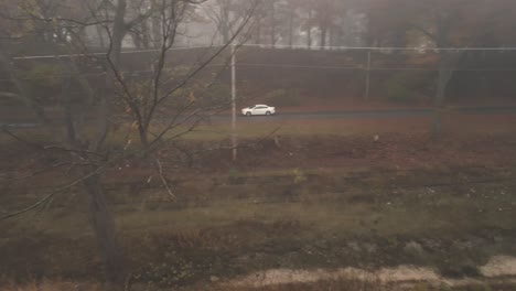 a car speeding quickly down a slick road on a misty morning