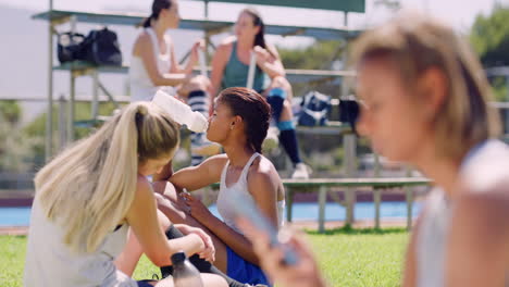 diverse team of sports players drinking water