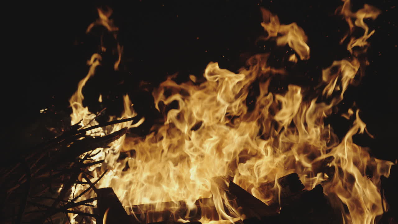 A bonfire with intense flames and burning wood