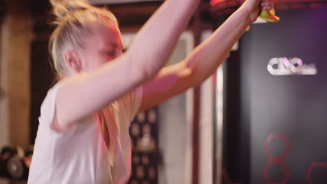 Side-View-Of-Young-Woman-Exercising-On-Cable-Machine-At-Fitness-Club-4