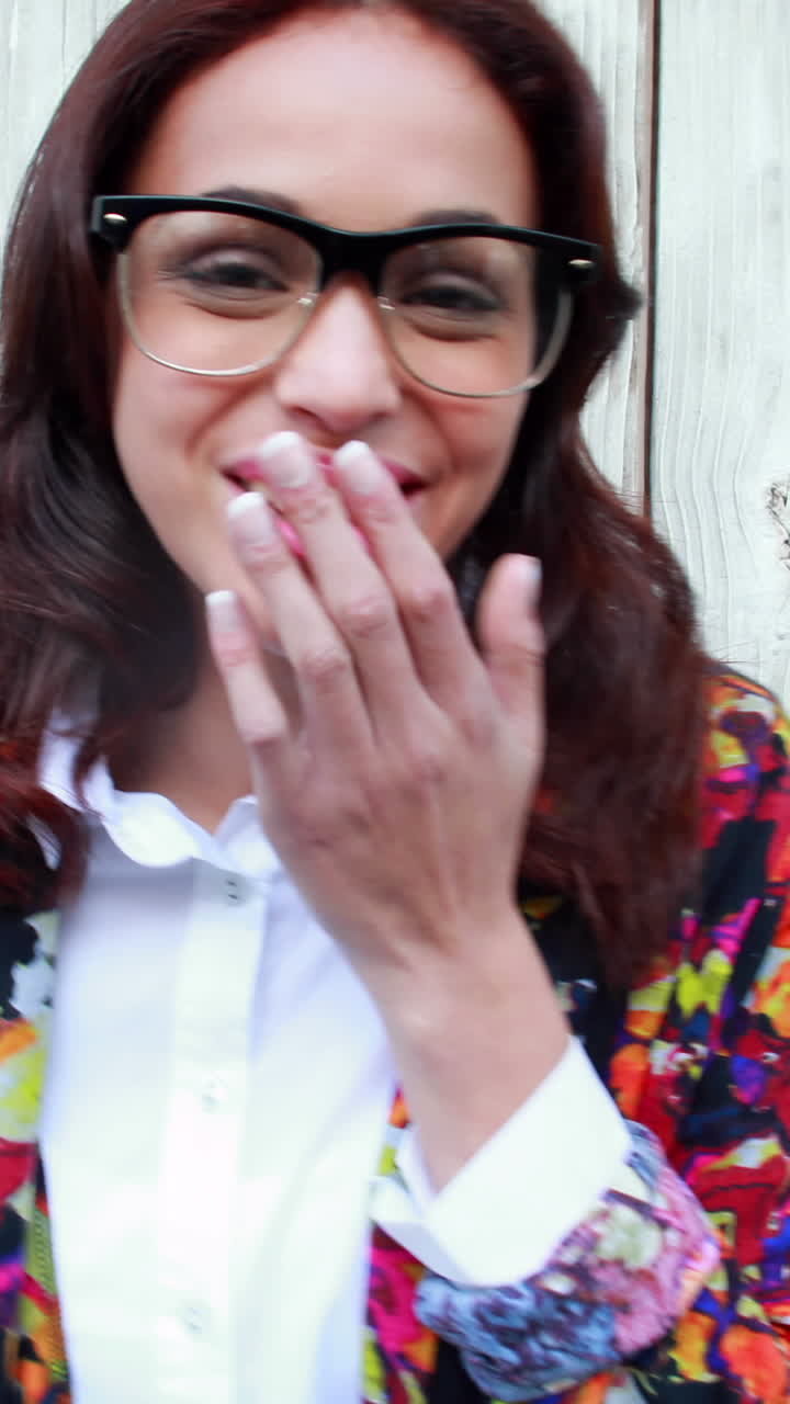 mujer hipster con gafas soplando un beso