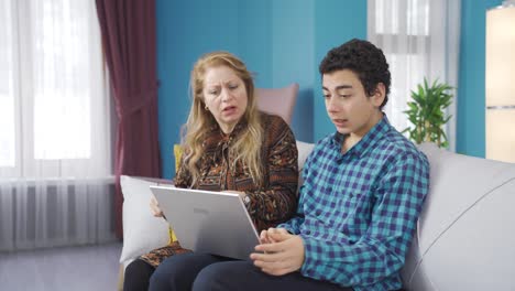 Madre-E-Hijo-Mirando-Una-Computadora-Portátil-En-Casa-Reciben-Buenas-Noticias-Y-Se-Regocijan.