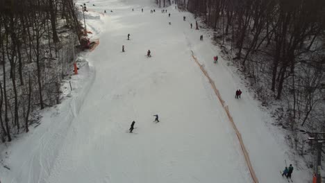 Drone-view-at-slope-on-ski-resort.-Forest-and-ski-slope-from-air.-Winter-landscape-from-a-drone.-Snowy-landscape-on-ski-resort.-Aerial-photography