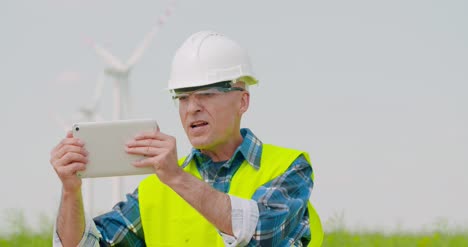 male engineer video conferencing against windmills 5