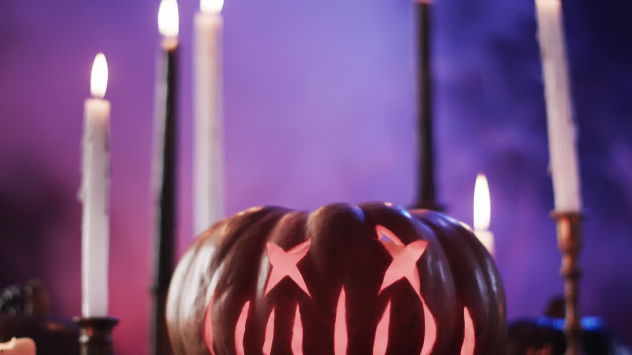 видео с вырезанной тыквой, свечами и дымом с копировальным пространством на фиолетовом фоне