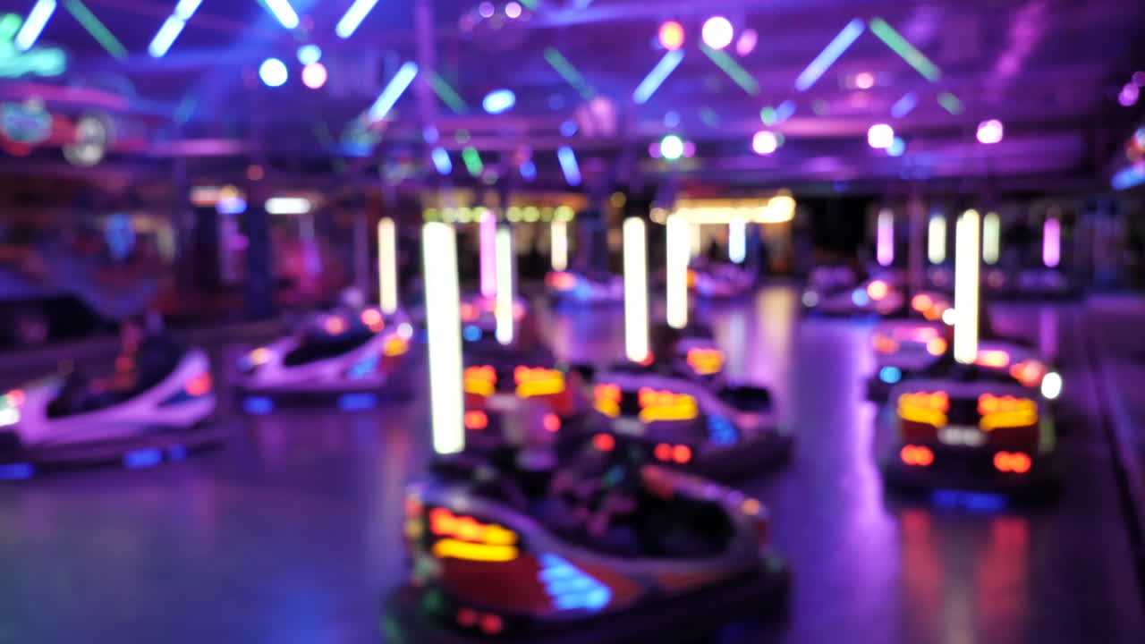 Bumper cars riding out of focus,during spinning disco lights,static shot