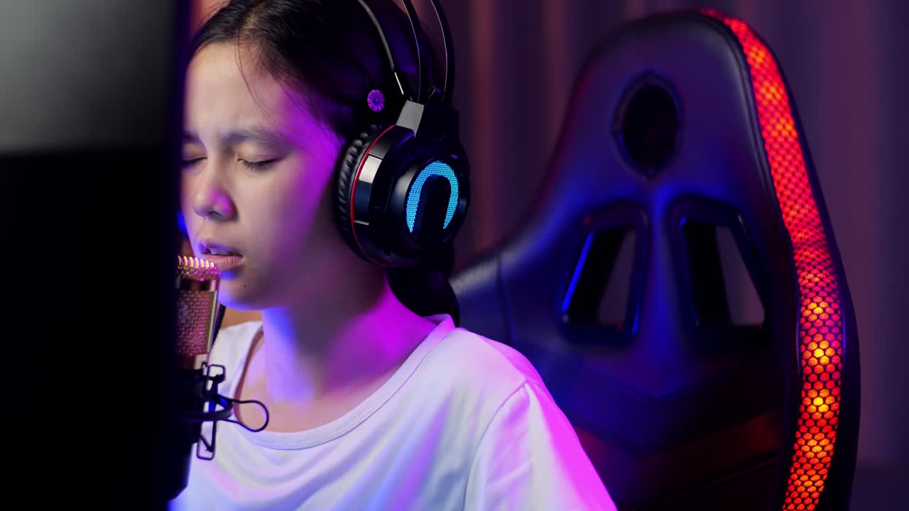 Close Up Of Asian Girl Streamer Playing Game Over Network On Personal Computer. Yawning And Sleeping, Live Stream Video Game, Desk Illuminated By Rgb Led Strip Light
