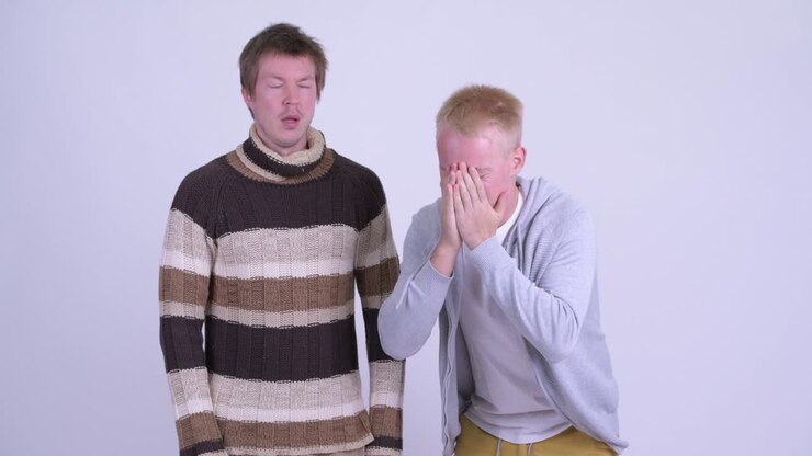 Two stressed young men getting bad news together