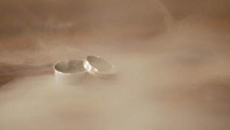 연기가 나는 나무 카운터에 있는 결혼 반지 - 슈퍼 슬로우 모션 - 60초