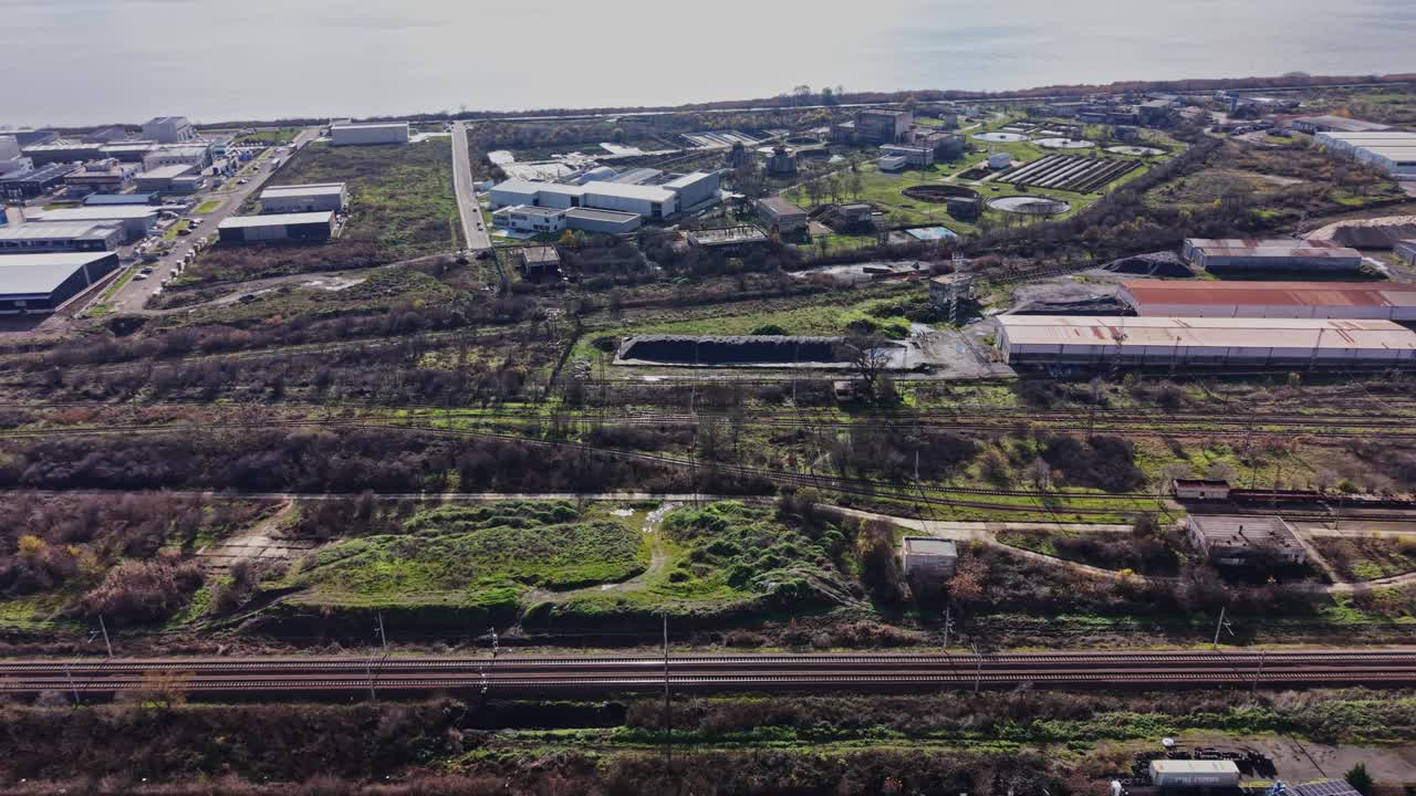 Industrial area with warehouses and vehicles near a waterfront