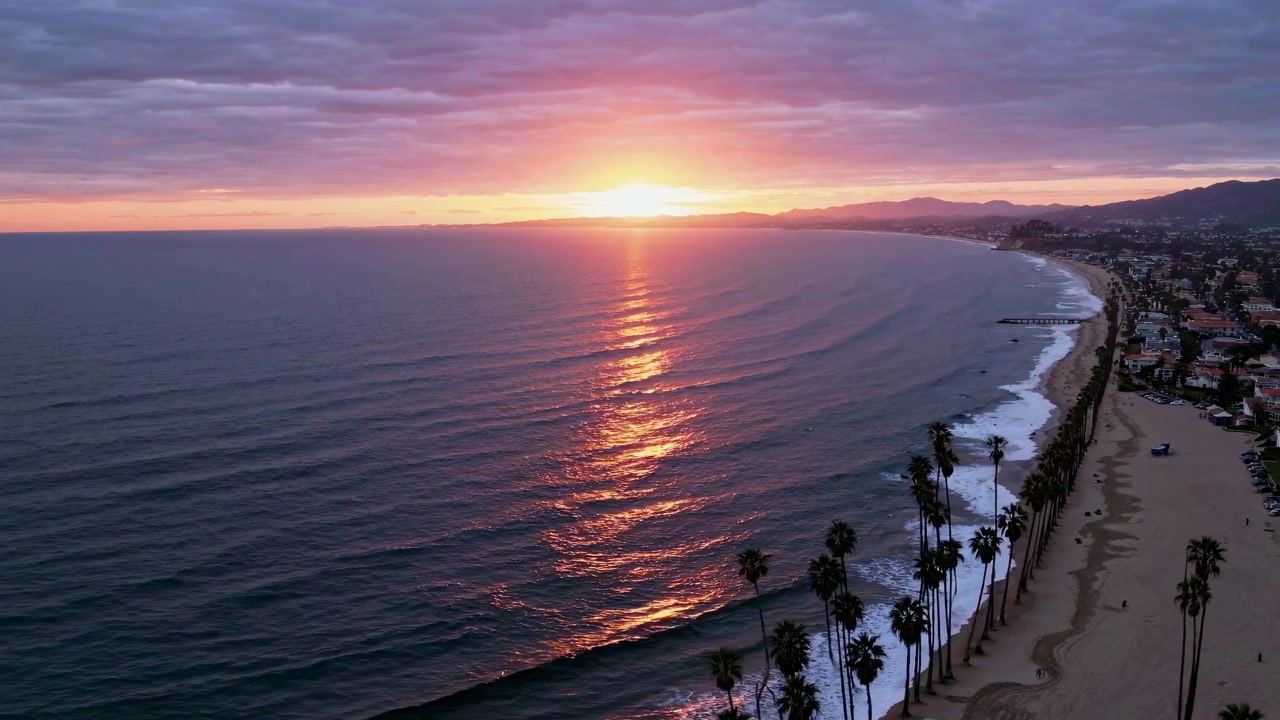 Vista aerea di una spiaggia californiana al tramonto con palme