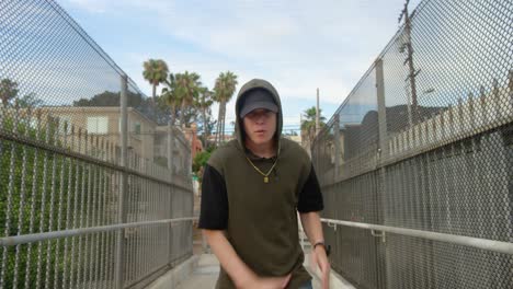 man freestyle hip hop dancing across freeway overpass in city