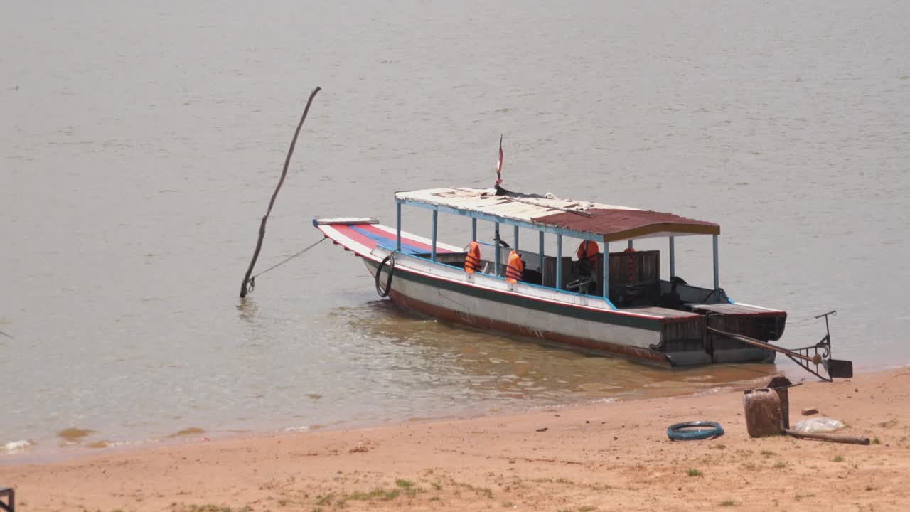 un barco tradicional jemer en la orilla de un lago en camboya.