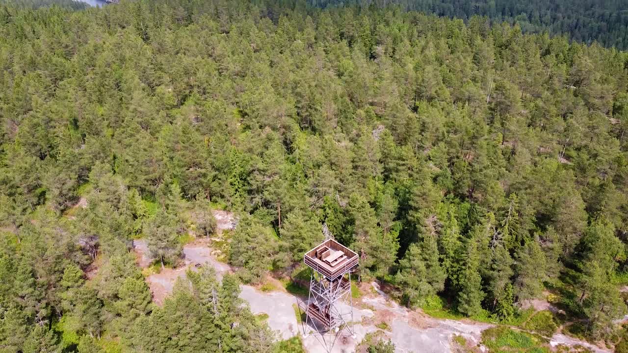vista aérea de una torre de topografía ubicada en un vasto bosque noruego, rodeada de densa vegetación y terreno accidentado