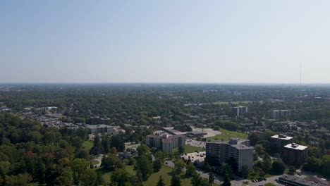 Flying-over-a-sunny-and-hazy-London-suburb-showing-trees-and-apartment-buildings