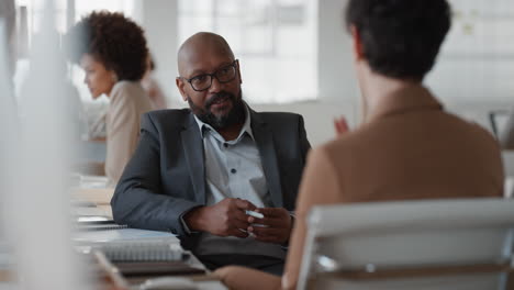 african american businessman chatting to intern discussing job interview colleagues having conversation in office enjoying teamwork