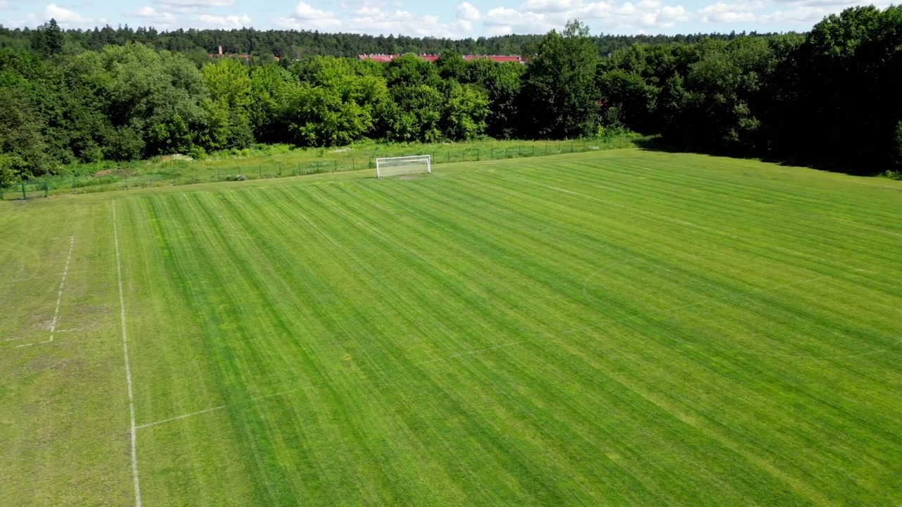 Dronekuva jalkapallokentästä vihreällä nurmella ja maaleilla.