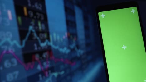 green screen smartphone, vivid stock market chart as background. stock market concept
