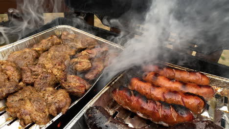 sausage and grilled pork neck on aluminum trays a lot of smog and fire