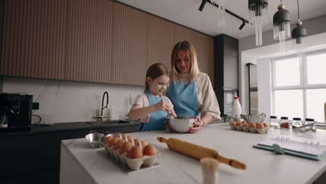 Glückliches-Kleines-Mädchen-Und-Ihre-Mutter-Kochen-Am-Sonntagmorgen-In-Der-Heimischen-Küche-Teig-Für-Pfannkuchen