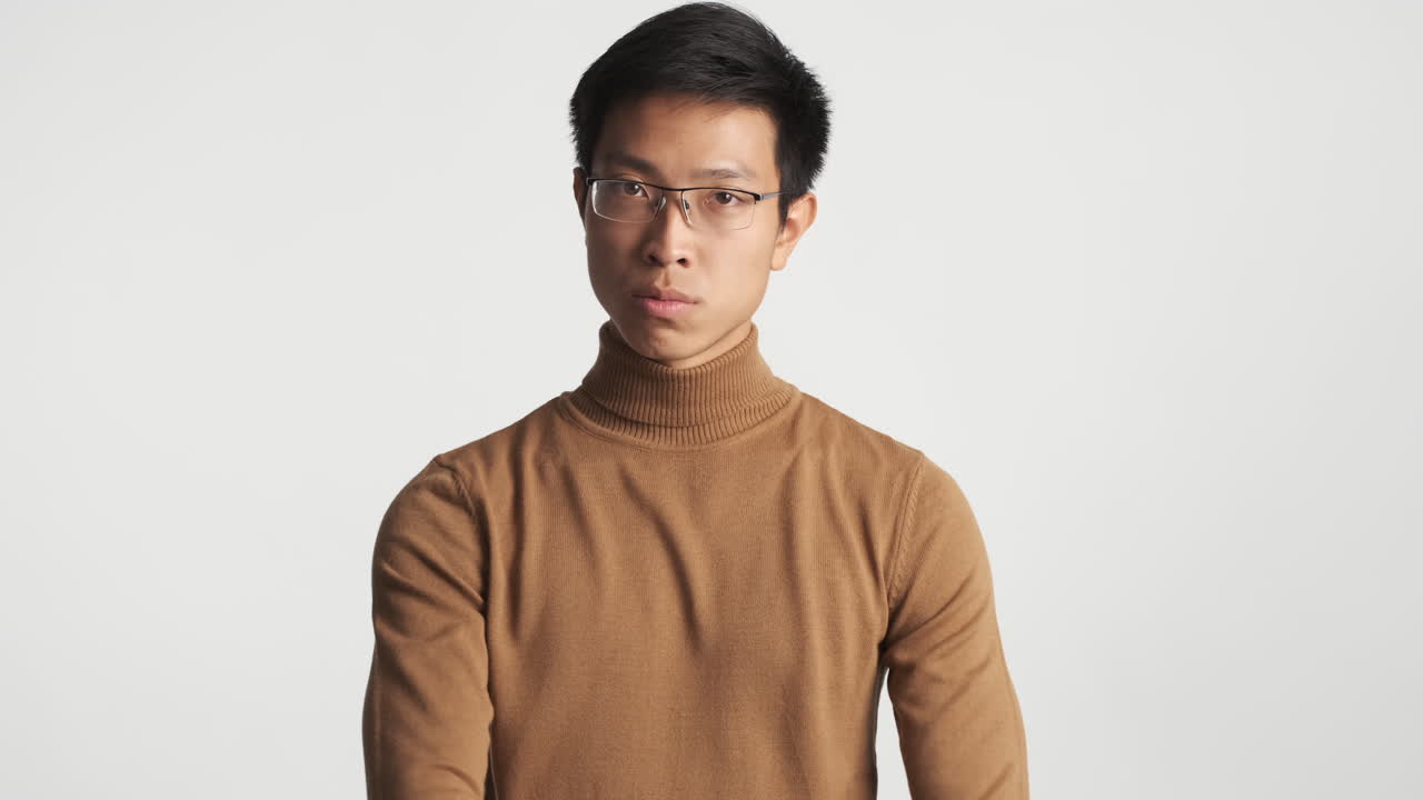진지한 아시아인 남자가 제스처를 보여주지 않습니다.