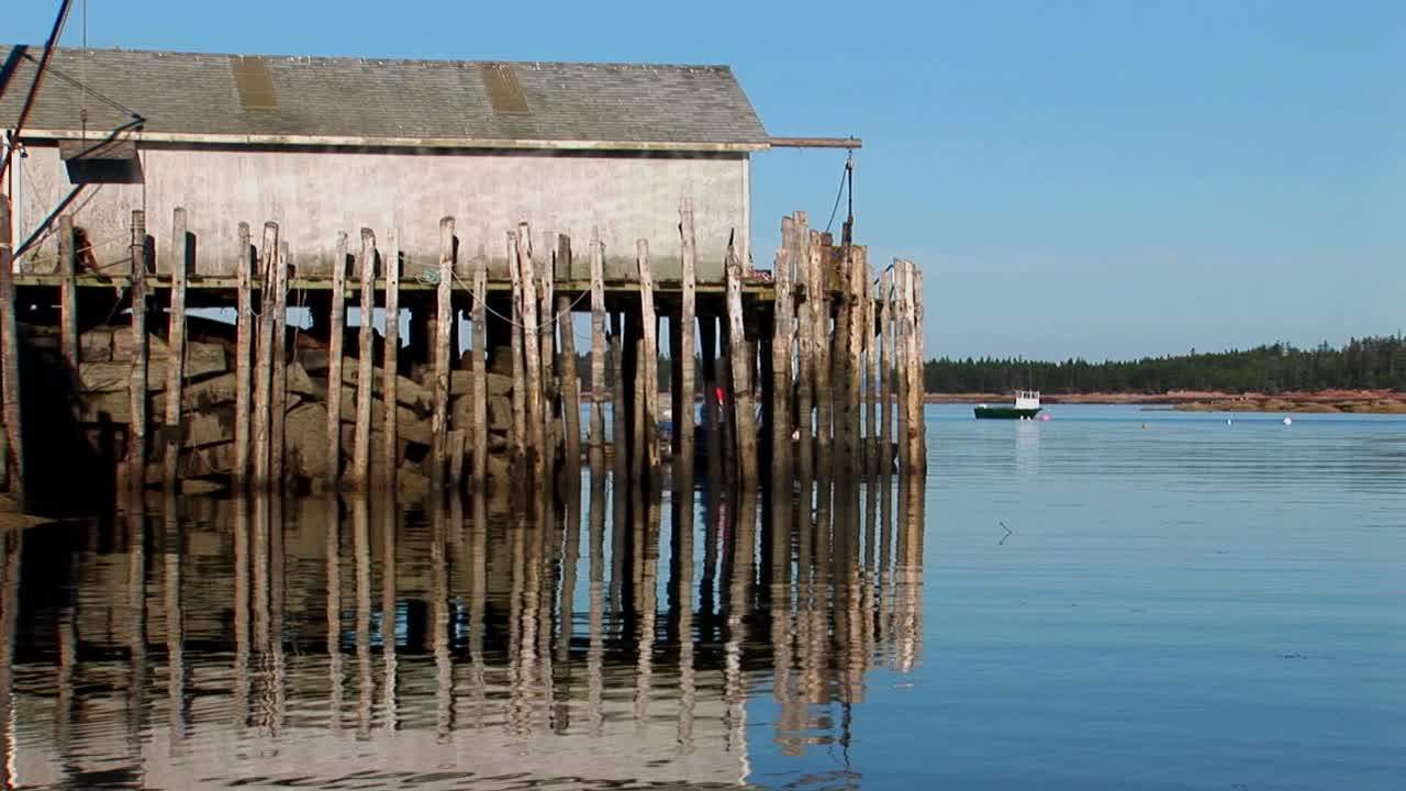 스토닝턴 메인에 있는 랍스터 마을에서 건물은 나무 기둥과 바위로 물 위에 고정되어 있습니다.