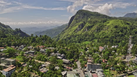 Ella-Sri-Lanka-Aerial-v35-drone-flyover-town-center-nestled-in-central-highlands-capturing-hillside-resort-hotels,-residential,-verdant-valleys-and-mountainscape---Shot-with-Mavic-3-Cine---April-2023