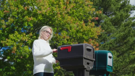 Frau-Sammelt-Post-Aus-Dem-Briefkasten