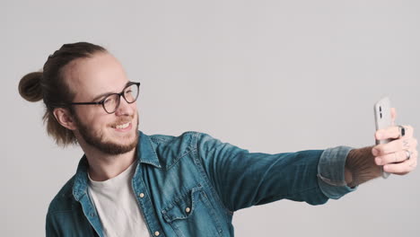 caucasian young man taking selfies on smartphone.