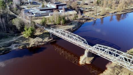 Antenne-Gründung-Drehen-über-Lettischen-Brücke-Fluss-überqueren-Landschaft-Dorflandschaft