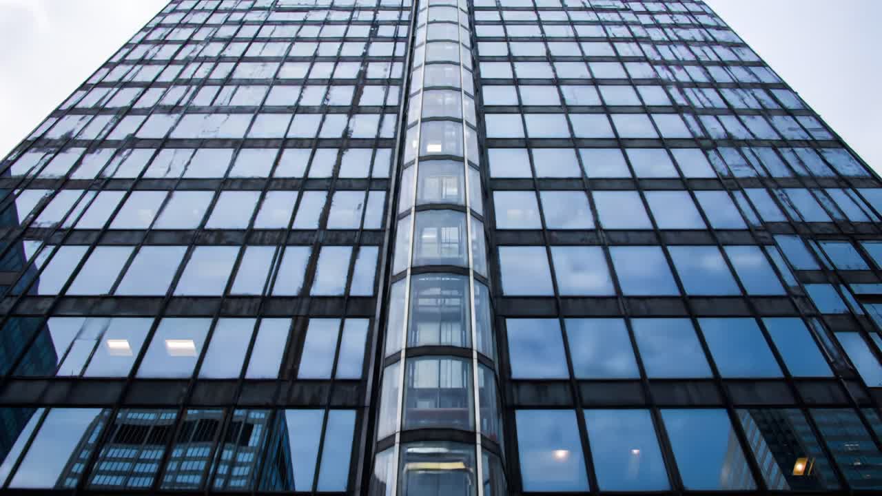 A Stunning Reflection: A Tall Glass Building Showcasing Modern Architecture and Urban Design from a Low Angle Perspective Against the Sky