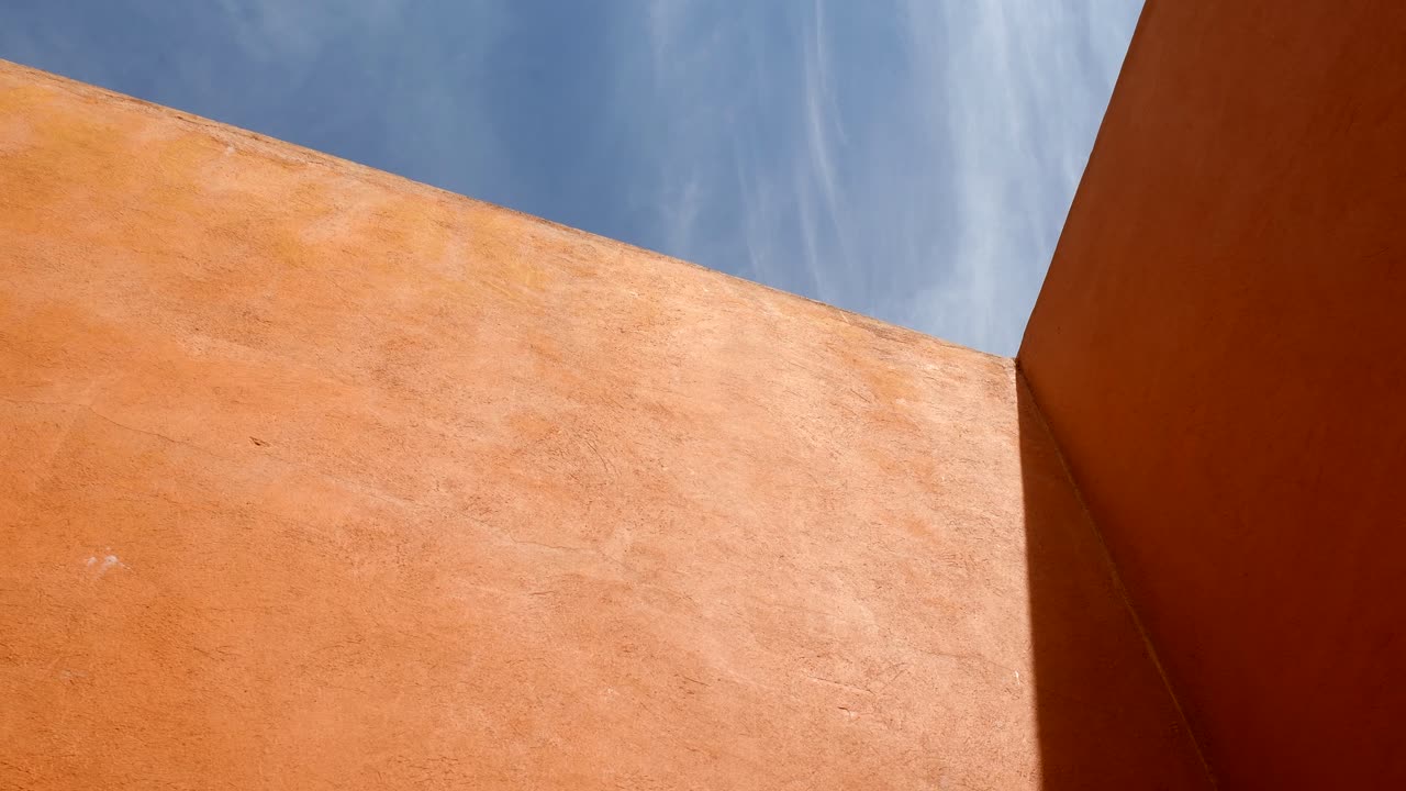 Light Beam On The Structure Of Orange Walls With Blue Sky Above. wide shot