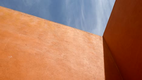 light beam on the structure of orange walls with blue sky above. wide shot