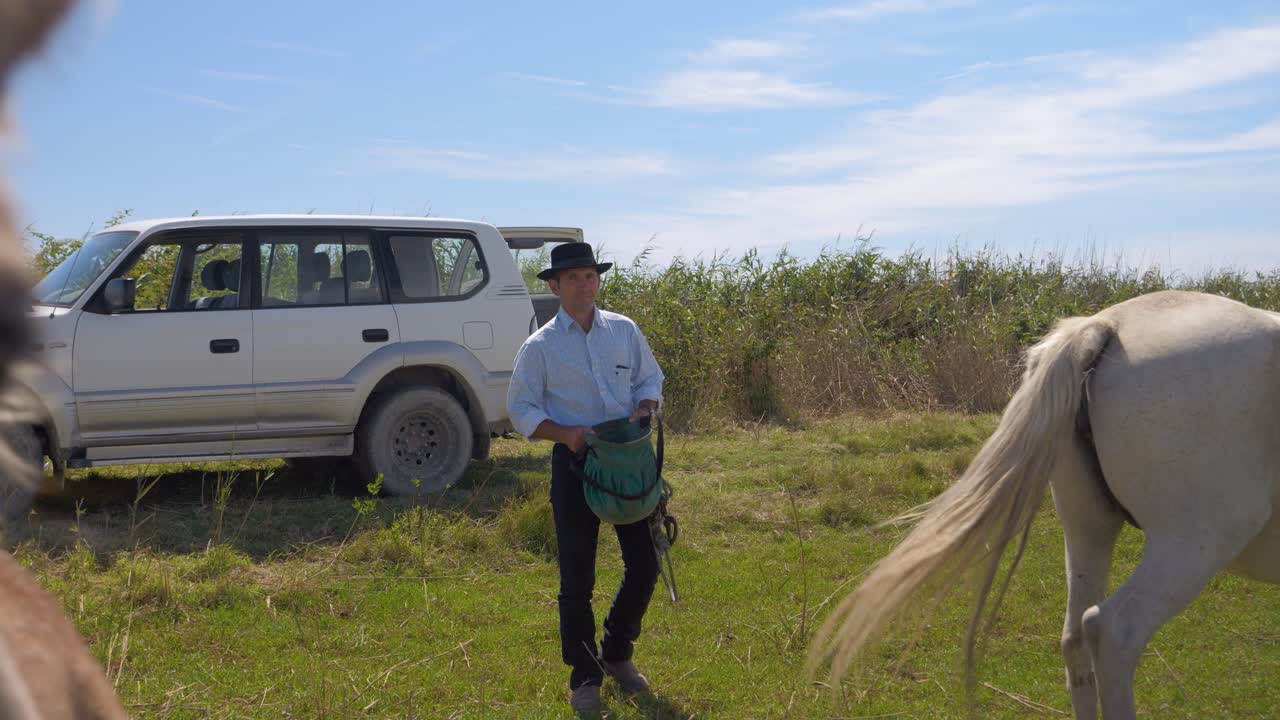 그가 그들을 위해 음식을 가지고 말을 보여주기 위해 차 밖으로 걸어가는 카우보이