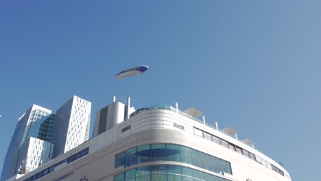 goodyear blimp flying over city buildings