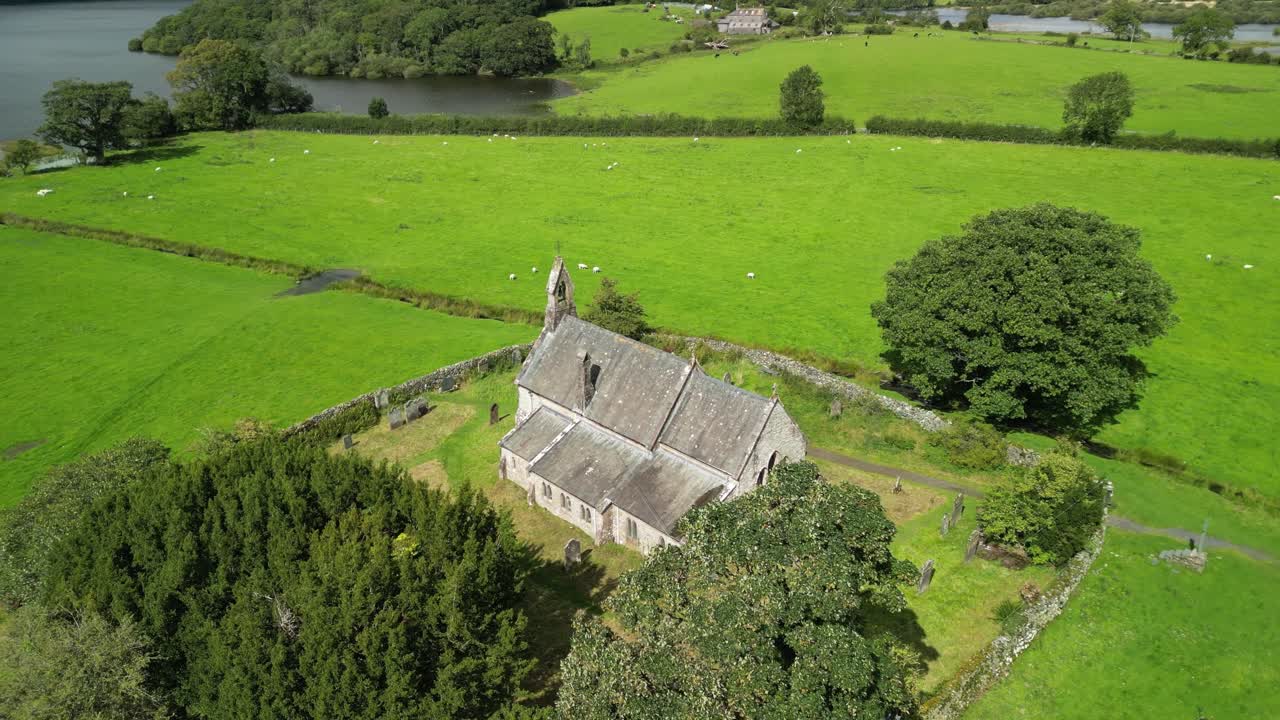 The legendary St Bega’s Church, Bassenthwaite, Lake District, full of folklore - Aerial drone pull back anti-clockwise rotate to reveal lake