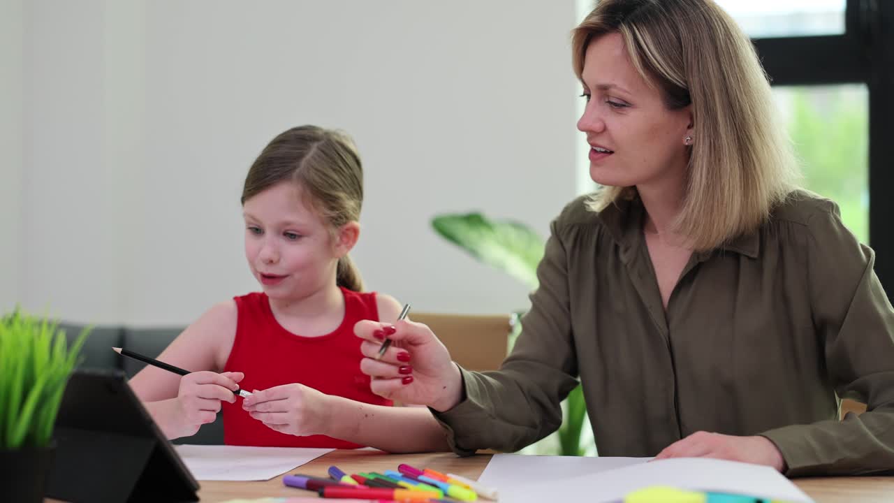 Donna sorridente aiuta una bambina a fare i compiti con un tablet