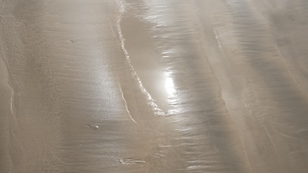 해빛이 물결이 낮을 때 은 모래 해변에 반사되어 아름답고 조용한 풍경을 만니다.