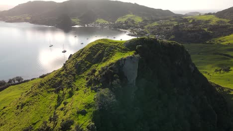 Travelers-enjoying-view-of-amazing-coastal-scenery-of-Northland,-New-Zealand---aerial-drone-pullback