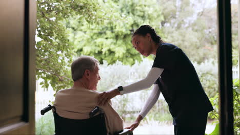 Caregiver,-talking-and-man-in-a-wheelchair-outdoor