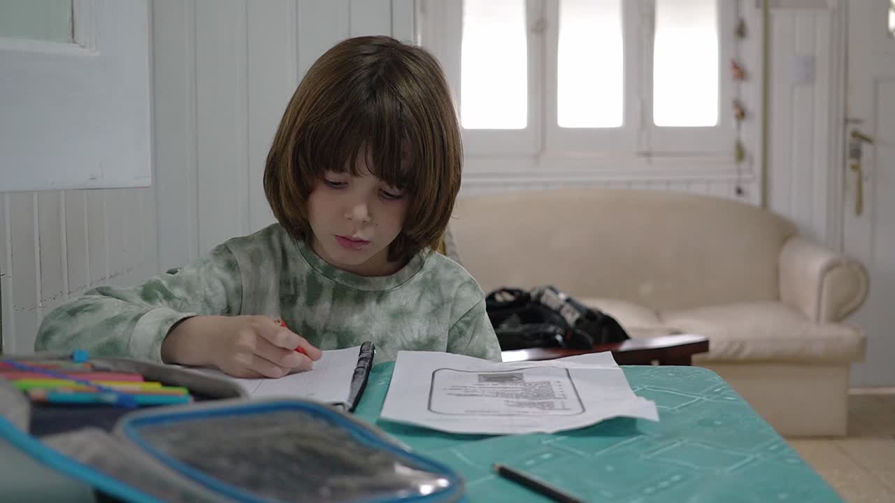 Close view of a little boy at home doing his homework.