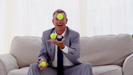 un hombre de negocios jugando con una pelota de tenis.