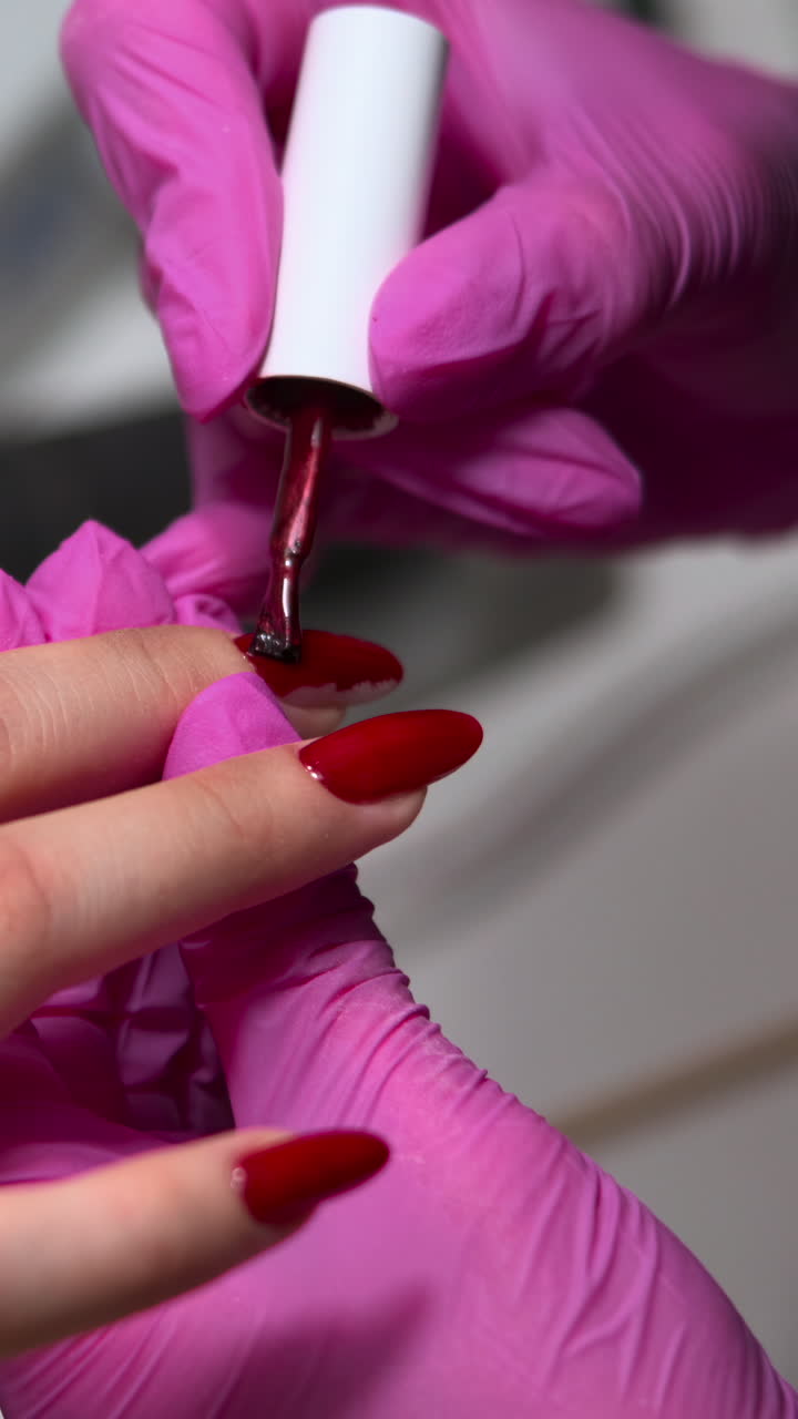 Manicurist in Pink Gloves Applying Red Nail Polish to Client's Nails
