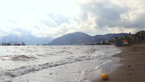 waves-on-dirty-beach-sand-i-a-cloudy-day---Marmaris,-South-of-Turkey