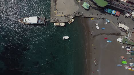 breathtaking drone video of positano beach, showcasing vibrant boats, shimmering waters, and sandy shoreline. captivating aerial footage captures the essence of coastal italy