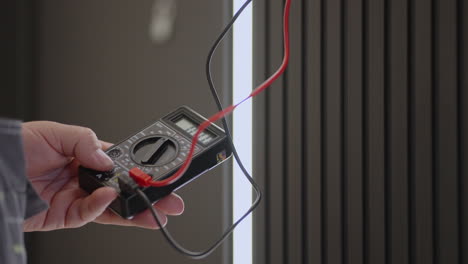 close-up electrician checks the voltage with a special device. electrician tester to check current