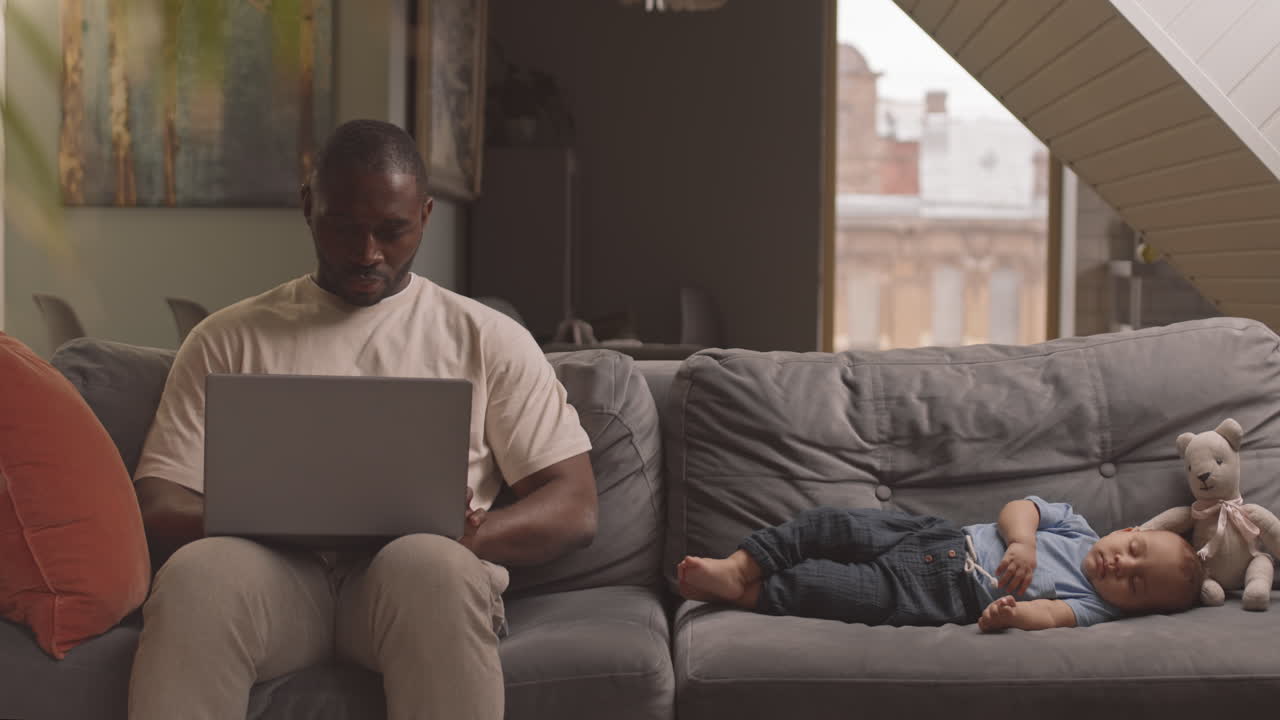 Man Working Near Sleeping Child